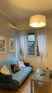 un soggiorno con divano blu e tavolo di Cozy apartment ideally located city center and Megaron Moussikis metro station ad Atene