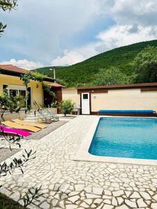 uma piscina ao lado de uma casa com uma montanha em Hacijenda za odmor iz snova uz potpunu privatnost em Mostar