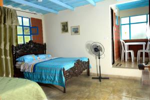 sypialnia z łóżkiem i wentylatorem w obiekcie Alex Country House w mieście Chachagüí