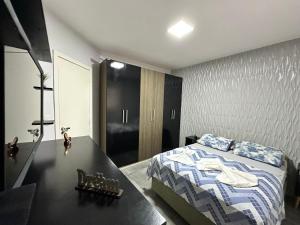 um quarto com uma cama e uma secretária preta com uma cama sidx sidx em Casa no centro de Xangrilá em Xangri-lá