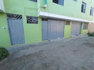 a building with four garage doors on the side of it at Hotel Huanchaco in Trujillo