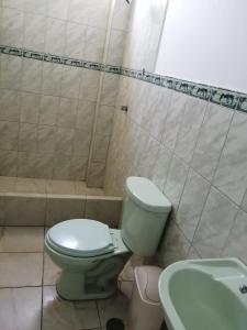 bagno con servizi igienici verdi e lavandino di Hotel Huanchaco a Trujillo