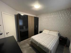 um quarto com uma cama e um armário preto em Casa no centro de Xangrilá em Xangri-lá