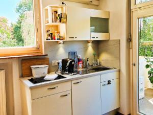 a kitchen with white cabinets and a sink and a window at Freiburg citynah - hell, ruhig, gemütlich in Freiburg im Breisgau