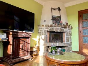 Yenne的住宿－Chambre d’hôte à Yenne avec grand salon，客厅设有石制壁炉和电视。