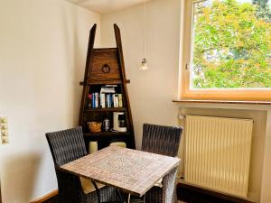 a table and chairs in a room with a book shelf at Freiburg citynah - hell, ruhig, gemütlich in Freiburg im Breisgau +3 photos