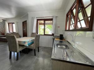 uma cozinha com um lavatório e uma mesa com cadeiras em Casa no centro de Xangrilá em Xangri-lá