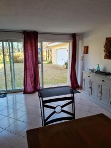 sala de estar con silla y ventana grande en Appartement Type F4, en Maurens