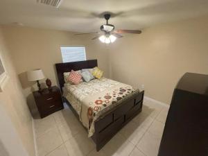 - une chambre avec un lit et un ventilateur de plafond dans l'établissement Abode Villas, à Cape Coral