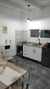 una cocina con fregadero y estufa horno superior en Cabañas Olluhuasi, en Valle Hermoso