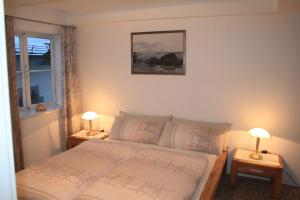 a bedroom with a bed with two lamps on tables at Fachwerkferienhaus Helmbrecht in Goslar