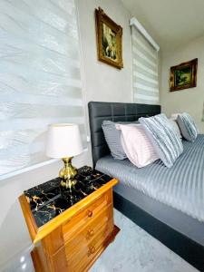 ein Schlafzimmer mit einem Bett und einem Tisch mit einer Lampe in der Unterkunft De-Luxe-Apartment im Zentrum in Ravensburg