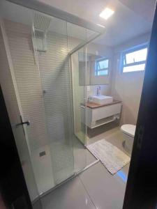 a bathroom with a glass shower and a toilet at Linda Casa com amplo jardim! in Curitiba