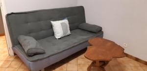 um sofá com uma almofada num quarto em John & Ghislaine em Donjeux