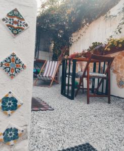 a patio with a table and a chair and flowers at DA FEDERICA Casa Vacanze BAIA PORTO DELLE GENTI in Lipari