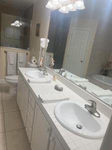 a bathroom with two sinks and a large mirror at Abode Villas in Cape Coral