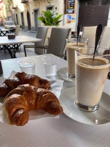 un tavolo con due piatti di croissant e due bicchieri di caffè di Casa in centro Randazzo a Randazzo