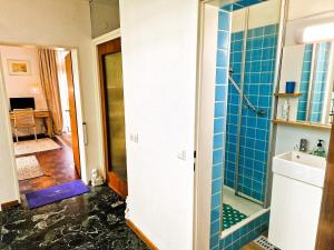 ein Bad mit einer Dusche und blauen Fliesen in der Unterkunft Freiburg citynah - hell, ruhig, gemütlich in Freiburg im Breisgau