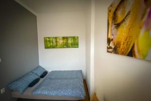 - une chambre avec un lit et une peinture murale dans l'établissement Lovely central apartment with free parking, Központhoz közeli 3 szobás lakás, à Győr