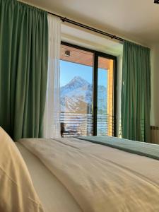 a bedroom with a window with a view of a mountain at Hotel Grand View in Stepantsminda