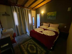 a bedroom with a red bed with white pillows at Pousada Villa Verde in Estância