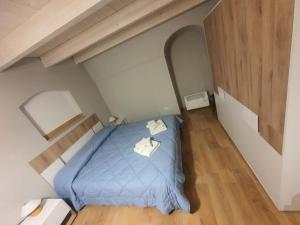 um pequeno quarto com uma cama azul num sótão em DomusD em Bernalda