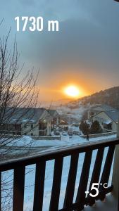 een winterzonsondergang boven een stad met sneeuw op de grond bij Superbe appartement Font Romeu La Pardallera in Font Romeu Odeillo Via