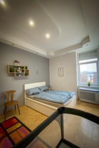 een slaapkamer met een bed, een stoel en een raam bij Lovely central apartment with free parking, Központhoz közeli 3 szobás lakás in Győr