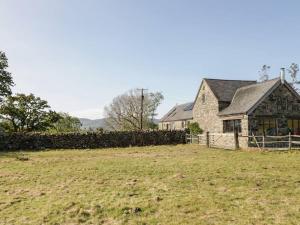 a house with a fence in front of a field at Pandy Farmhouse - Panoramic mountain views within Snowdonia's National Park - 4x4 recommended in Dolgellau