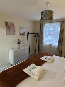 a bedroom with a bed with two towels on it at Charming 1-Bed Apartment in Stroud in Stroud