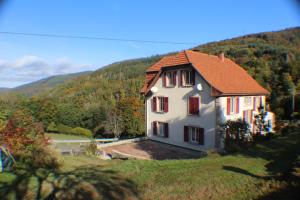 una casa blanca con techo rojo en una colina en Domaine de la Charrière sur 63 ares - 8 pers grand confort en Neuviller