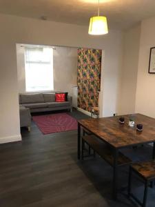 a living room with a table and a couch at Cardiff House 62 - CENTRAL LOCATION in Cardiff