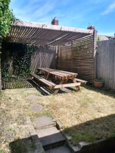 een picknicktafel in een achtertuin met een hek bij Cardiff House 62 - CENTRAL LOCATION in Cardiff