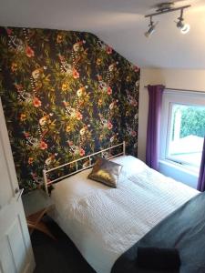 een slaapkamer met een bed met bloemenbehang bij Cardiff House 62 - CENTRAL LOCATION in Cardiff