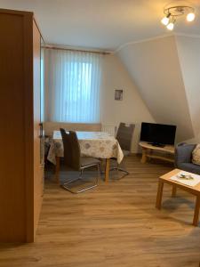 ein Wohnzimmer mit einem Tisch und einem Sofa in der Unterkunft Pension Haus Beckmann in Borkum