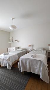 ブールゴアンにあるAtelier Liberationの白い壁とウッドフロアの客室で、ベッド2台が備わります。
