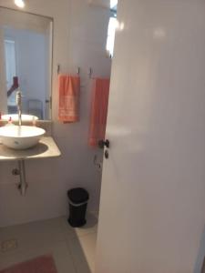 bagno con lavandino bianco e specchio di Apartamento vista Mar a Salvador