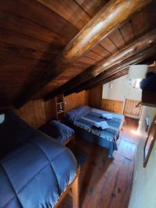 een kamer met 2 bedden op een houten zolder bij Cabañas Cultura Serrana in Santa Rosa de Calamuchita