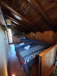 een slaapkamer met een bed in een houten hut bij Cabañas Cultura Serrana in Santa Rosa de Calamuchita