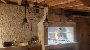eine Küche mit einem Kamin in einem Steinofen in der Unterkunft Villa Ana in Sevid