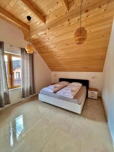 a bedroom with a bed in a room with wooden ceilings at ALPS Apartments in Kranjska Gora