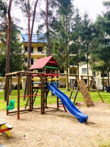 um parque infantil com um escorrega e uma estrutura de jogos em Blue Mare BB em Łukęcin