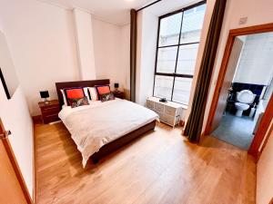um quarto com uma cama e uma grande janela em Excellent Entire Apartment Between St Pauls Cathedral and Covent Garden em Londres