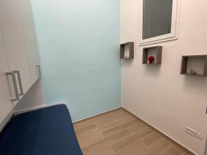 a room with a blue chair and a wall at Appartamento Cosy Centro Storico in Barletta