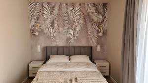 a bedroom with a bed with a wall with feathers at Apartament Sofia Kowary in Kowary