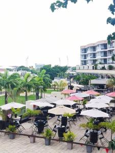 a group of tables and chairs with umbrellas at Three Bedroom at One Woodbrook Place in Port-of-Spain