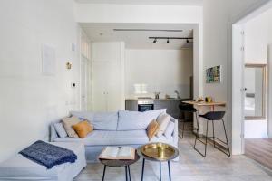 a living room with a white couch and a kitchen at Boutique Patio appalments next to Rothschild blvd in Tel Aviv