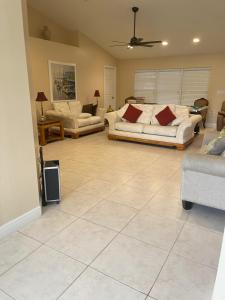 salon z 2 kanapami na podłodze wyłożonej kafelkami w obiekcie Abode Villas w mieście Cape Coral