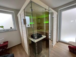 a bathroom with a sink and a glass shower at Ferienhaus Mountain View Six50 mit Sauna und Kamin in St. Andreasberg in Sankt Andreasberg +37 photos