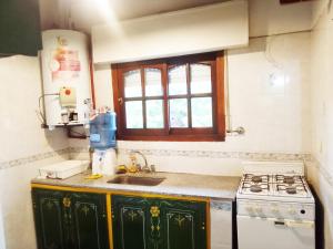 een keuken met een wastafel en een fornuis bij Norte, 310 in Villa Gesell